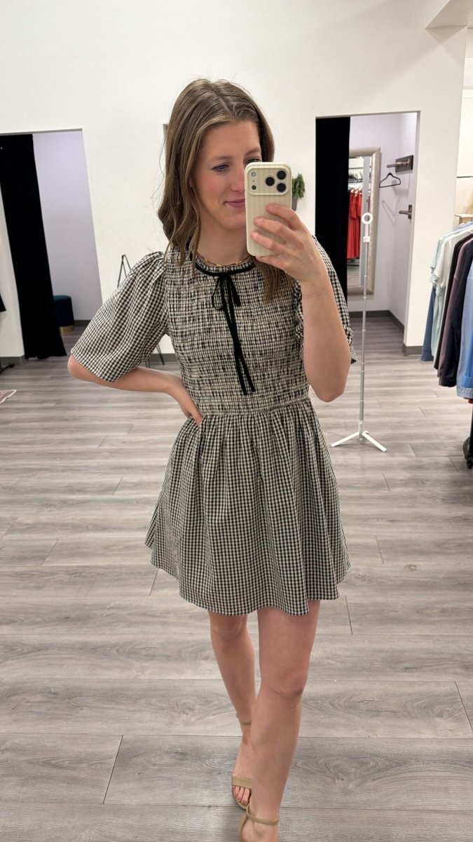 Front view of model wearing gingham smocked mini dress with shorts lining — Three:Twelve Boutique