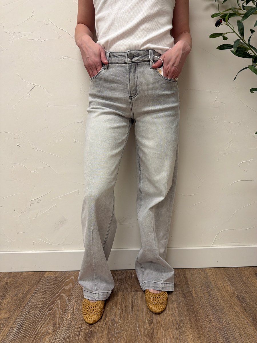 Lifestyle shot of model styled with casual top and sneakers wearing baggy jeans — Three:Twelve Boutique