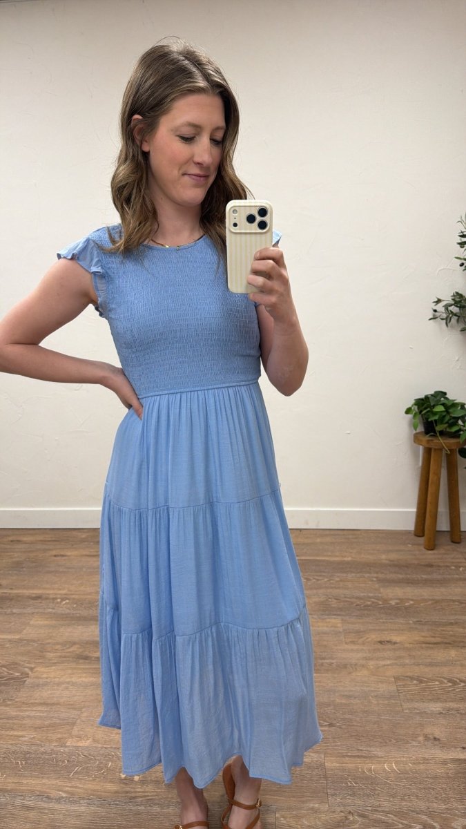 Lifestyle shot of model wearing tiered smocked midi dress in casual setting — Three:Twelve Boutique