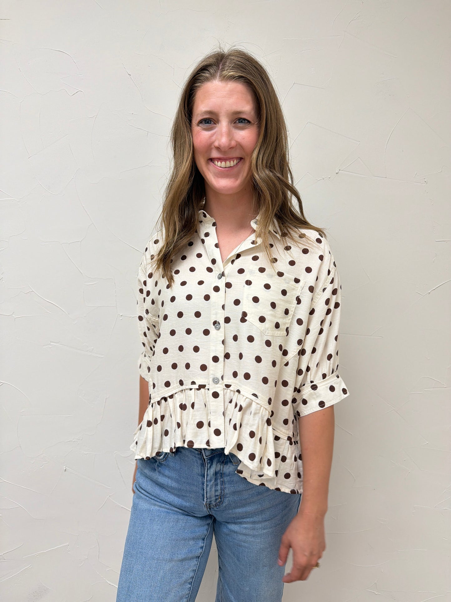 Polka dot waist-length top featuring ruffle hem