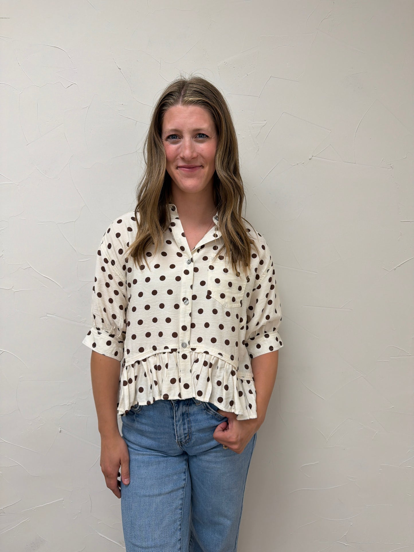 Polka dot waist-length top featuring ruffle hem