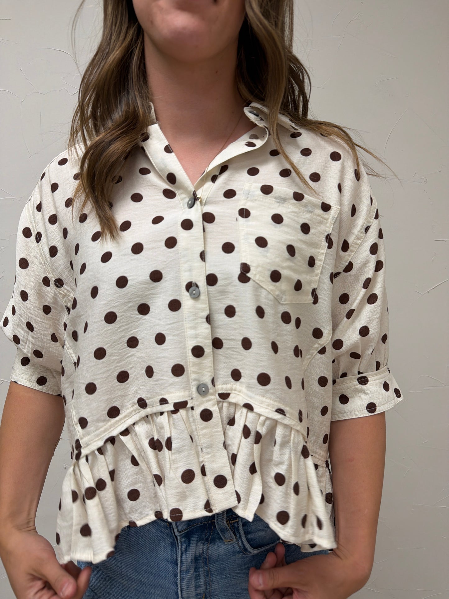 Polka dot waist-length top featuring ruffle hem