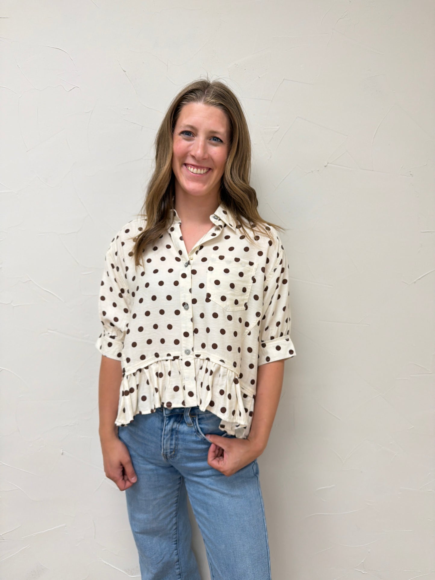 Polka dot waist-length top featuring ruffle hem
