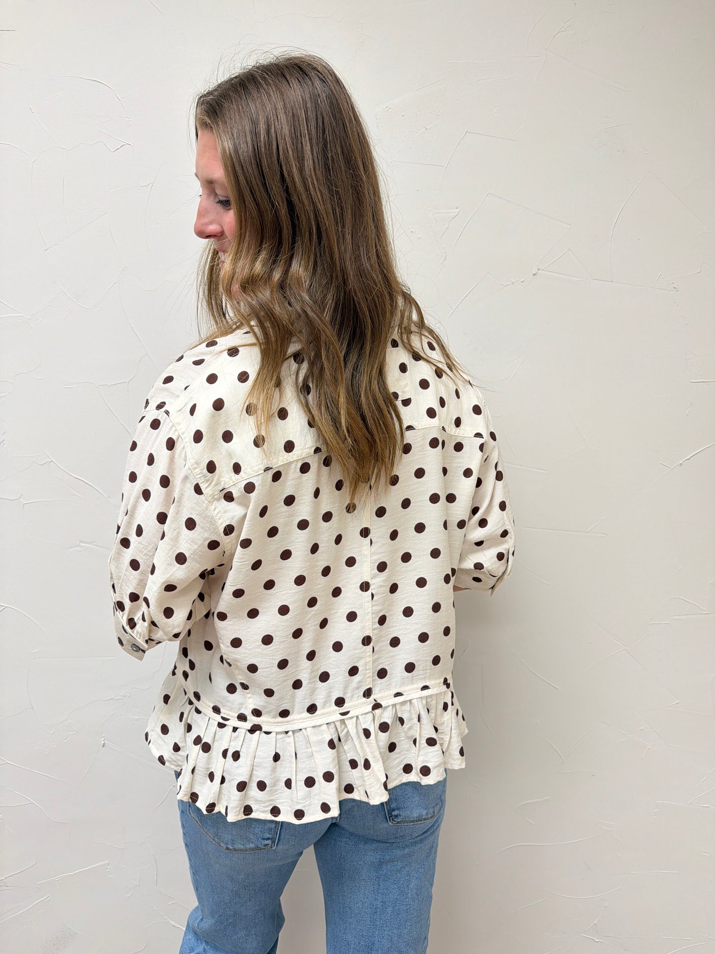 Polka dot waist-length top featuring ruffle hem