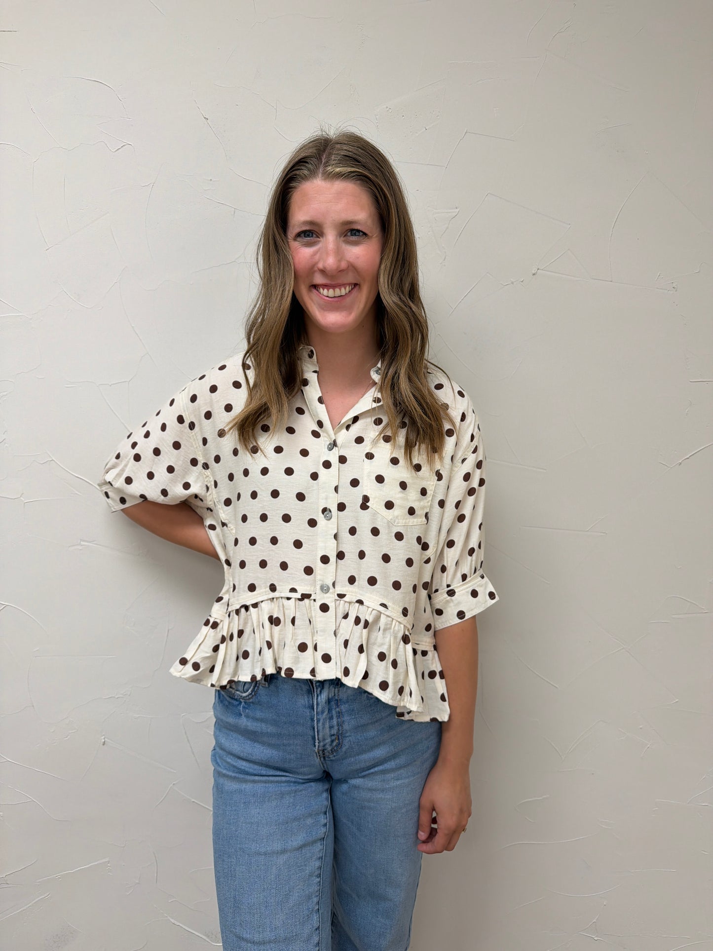 Polka dot waist-length top featuring ruffle hem