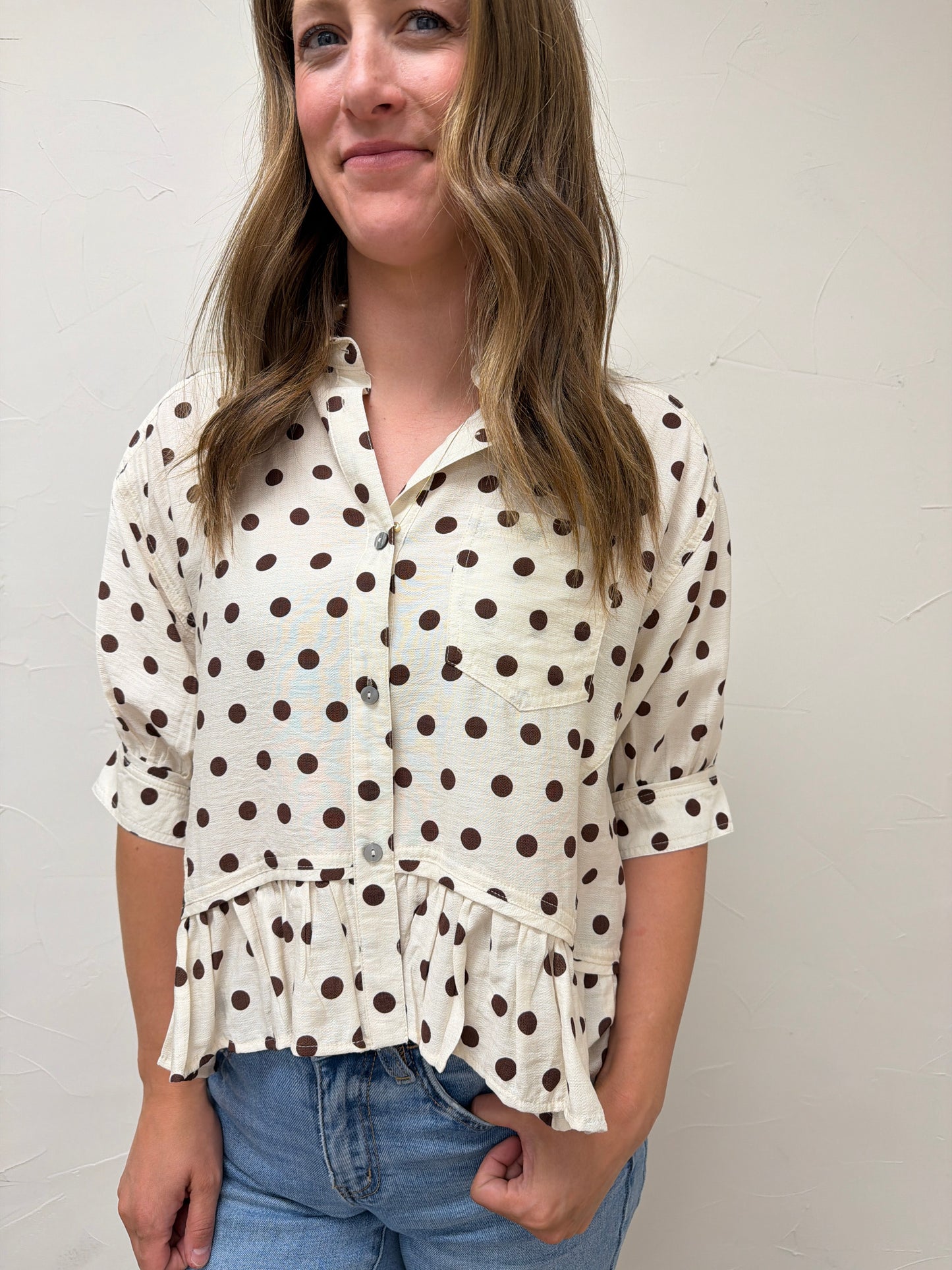 Polka dot waist-length top featuring ruffle hem