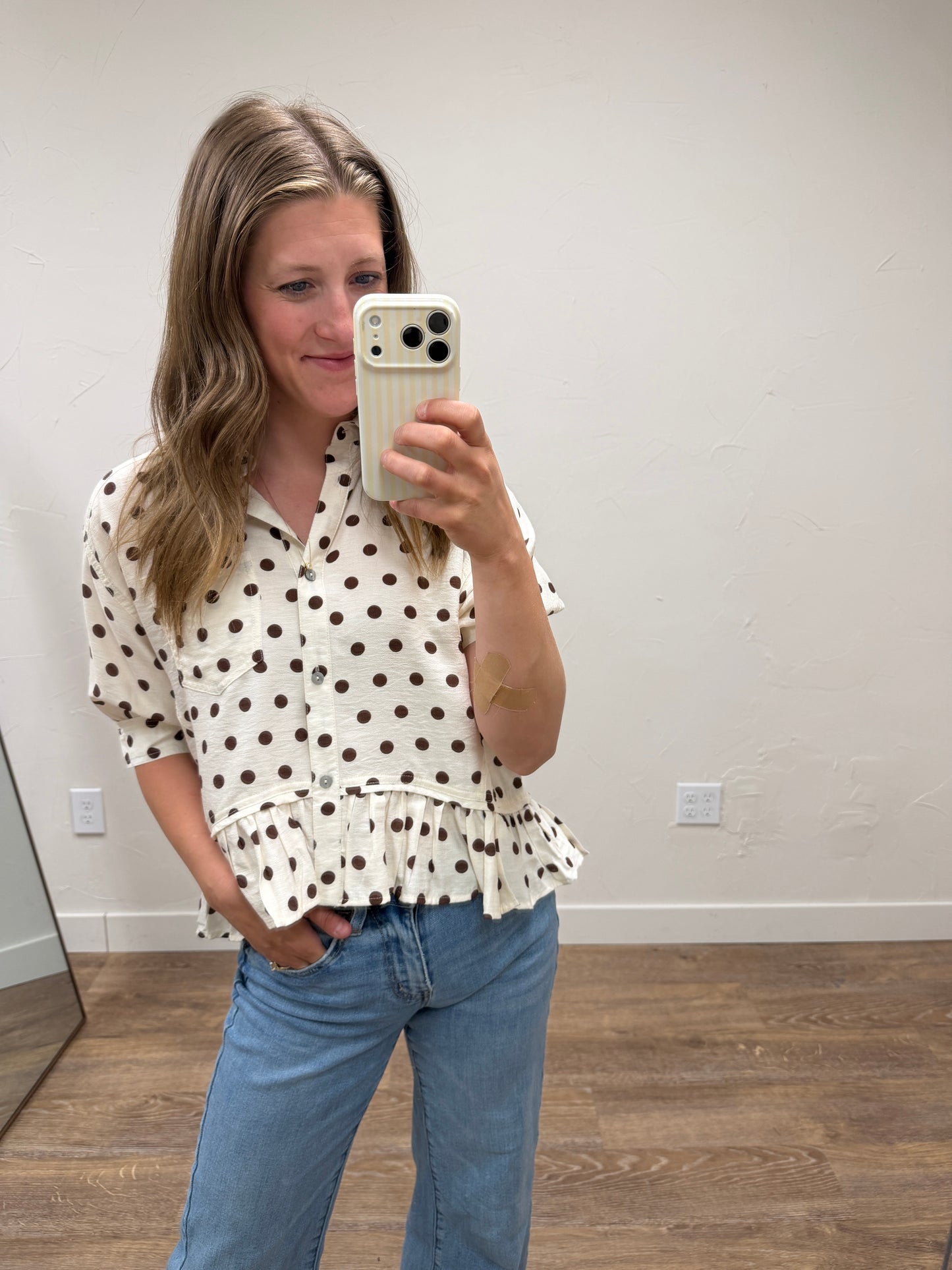 Polka dot waist-length top featuring ruffle hem