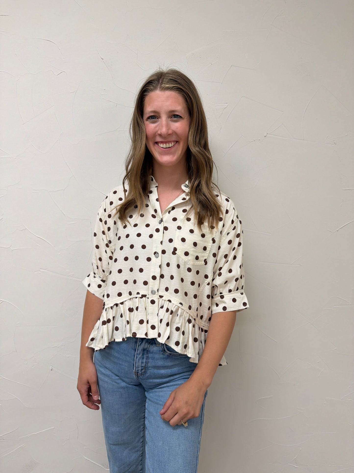 Polka dot waist-length top featuring ruffle hem