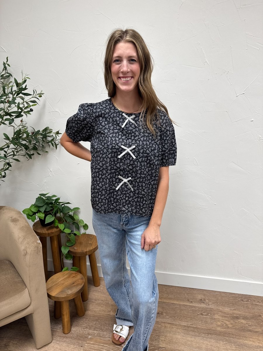 Lifestyle shot of model wearing floral blouse styled with casual outfit — Three:Twelve Boutique