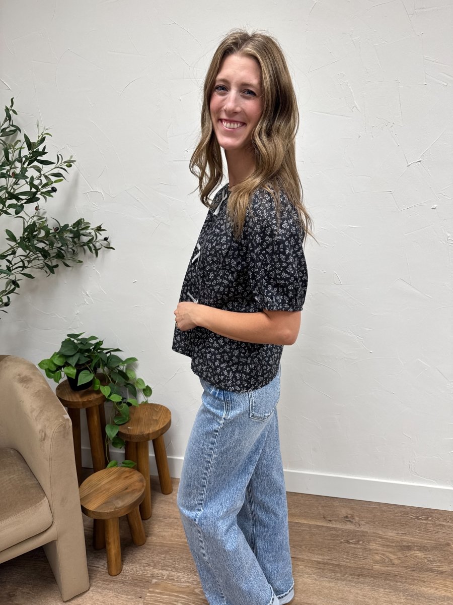 Side angle view of bow detail floral blouse showing drape and sleeve fit — Three:Twelve Boutique