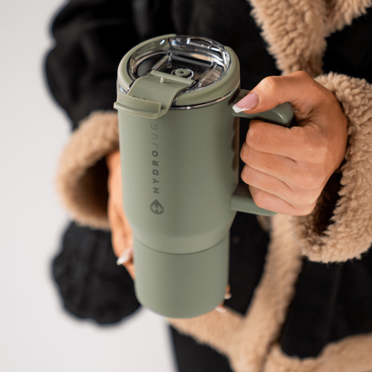 Lifestyle shot of travel coffee mug handed over by a girl — Three:Twelve Boutique