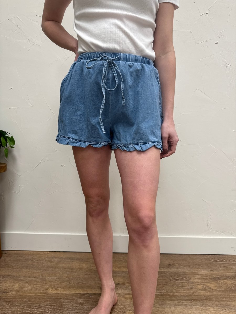Front view of denim ruffle hem shorts on model showing high rise fit — Three:Twelve Boutique