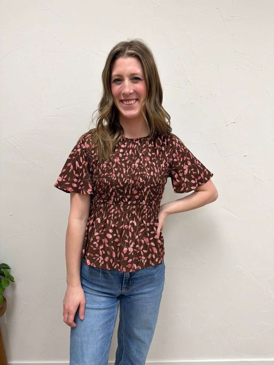 Lifestyle shot of model wearing floral peplum blouse styled with casual outfit — Three:Twelve Boutique