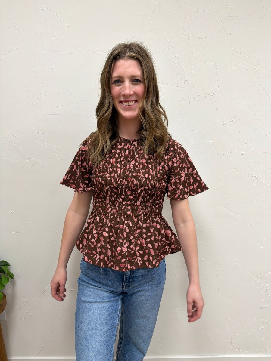 Lifestyle shot of model wearing floral peplum blouse styled with casual outfit — Three:Twelve Boutique