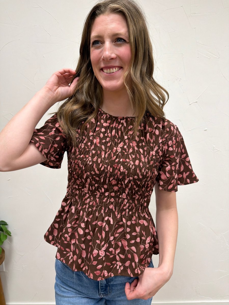 Close up of floral print and smocked fabric detail on blouse — Three:Twelve Boutique