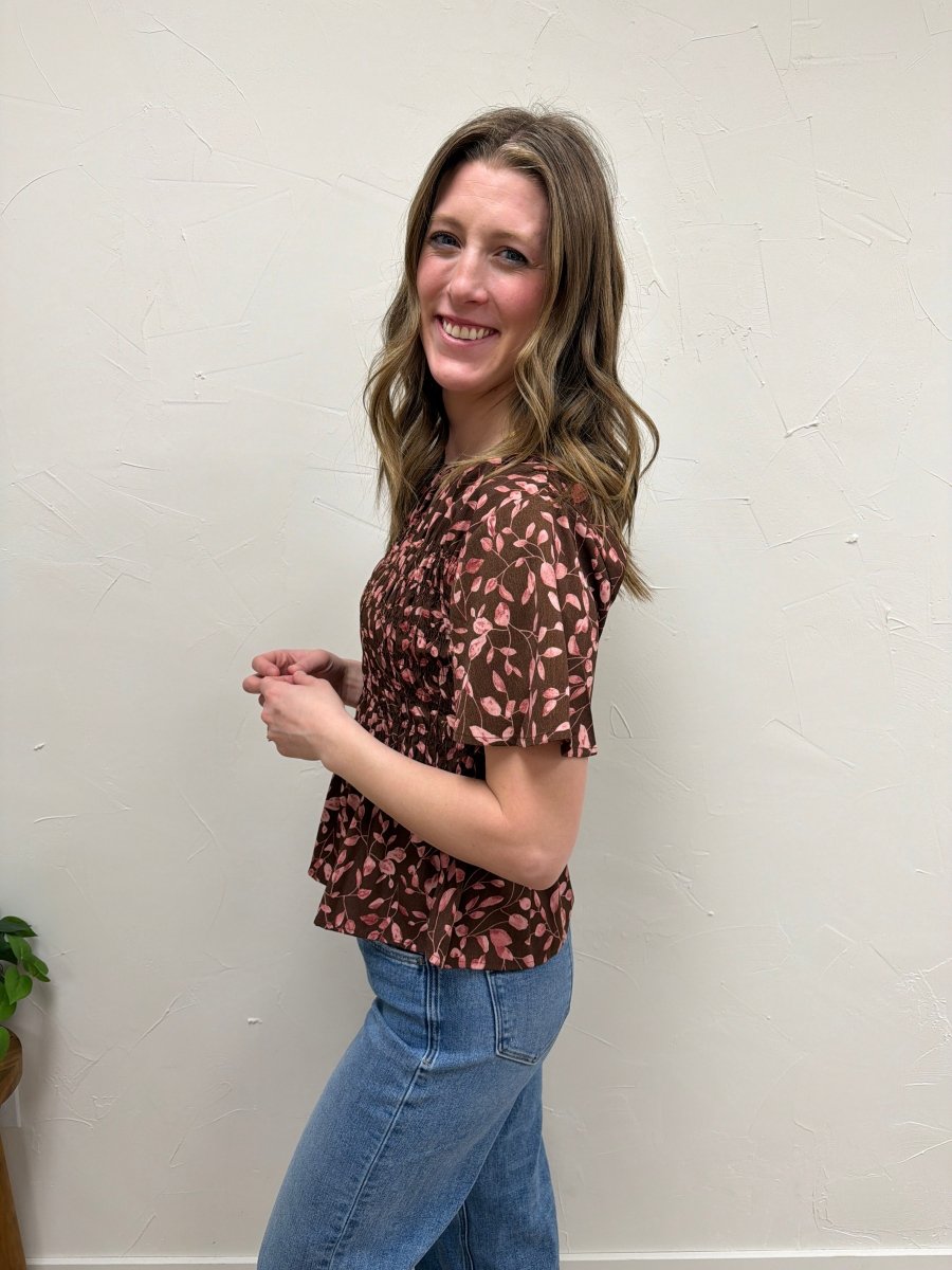 Side view of floral smocked peplum blouse showing flowy hem — Three:Twelve Boutique