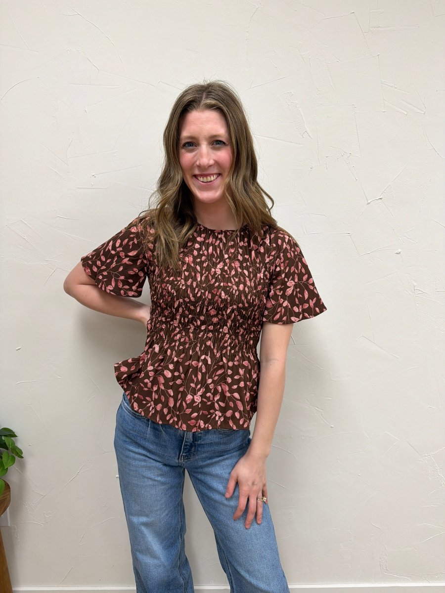 Lifestyle shot of model wearing floral peplum blouse styled with casual outfit — Three:Twelve Boutique