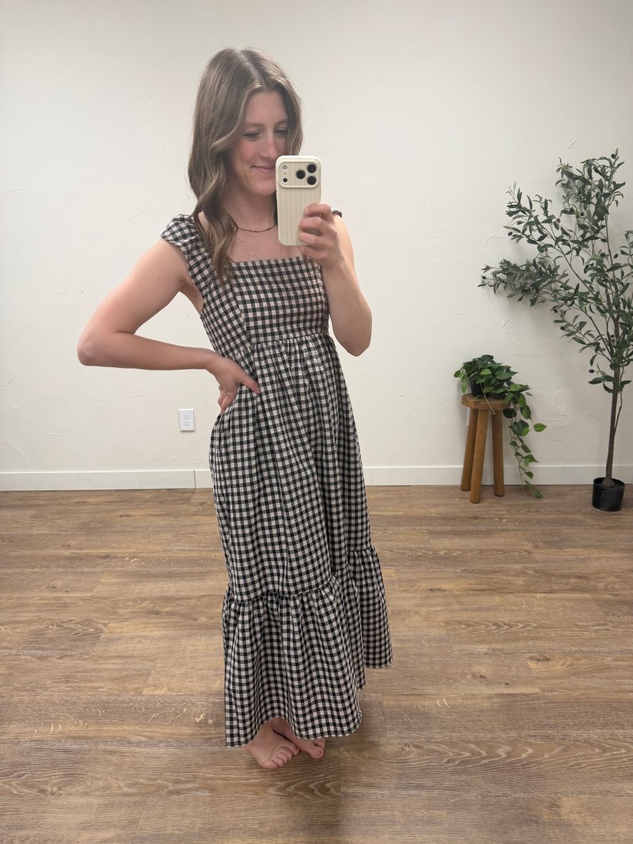 Lifestyle shot of model wearing gingham flutter sleeve dress in casual setting — Three:Twelve Boutique