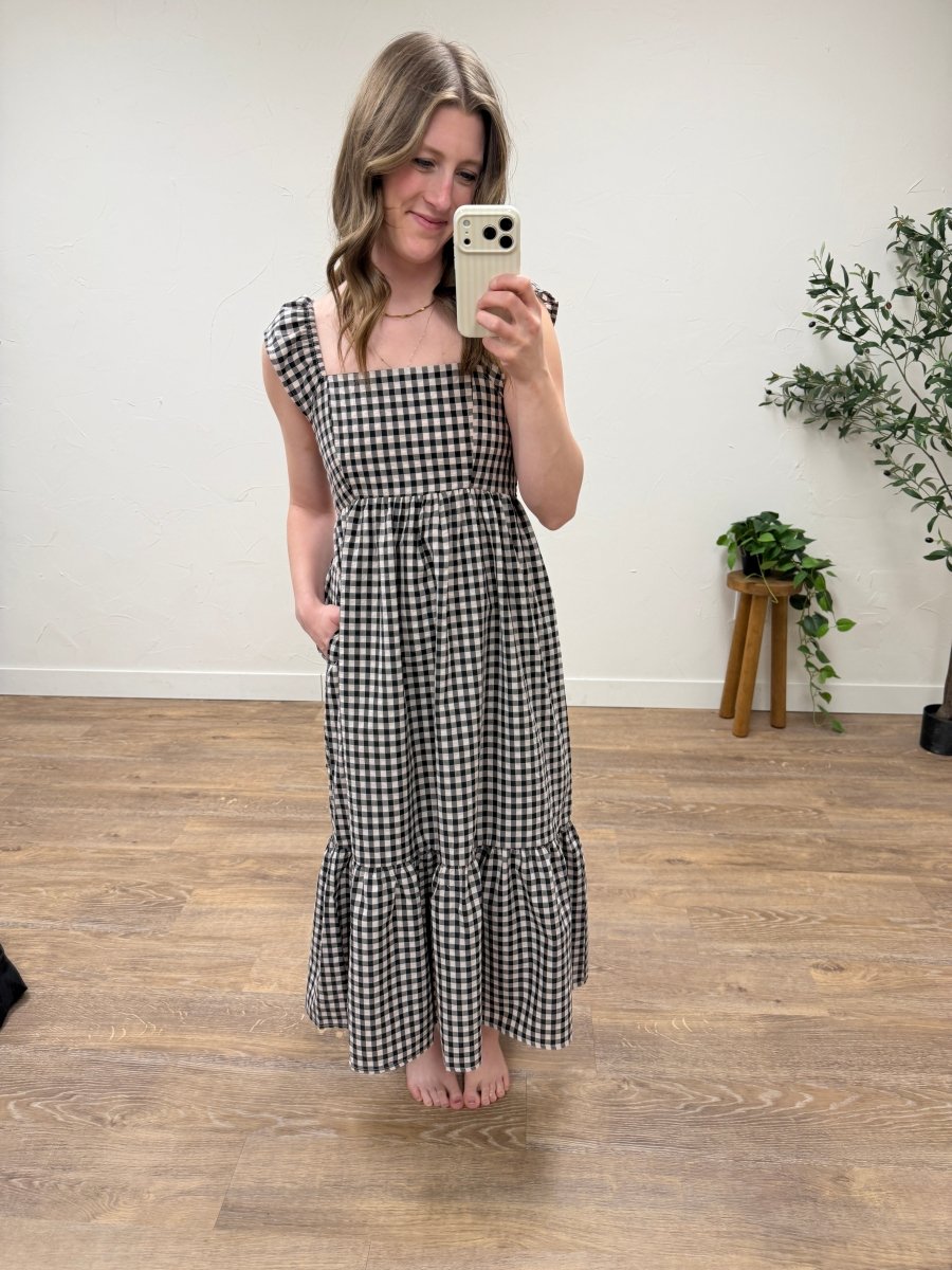Front view of blush and black gingham maxi dress with flutter sleeves on model — Three:Twelve Boutique