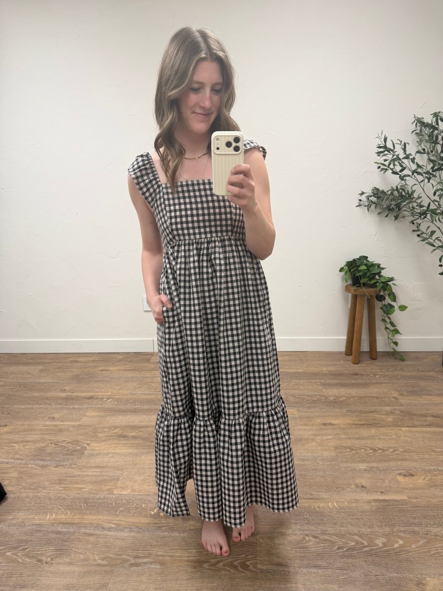 Front view of blush and black gingham maxi dress with flutter sleeves on model — Three:Twelve Boutique