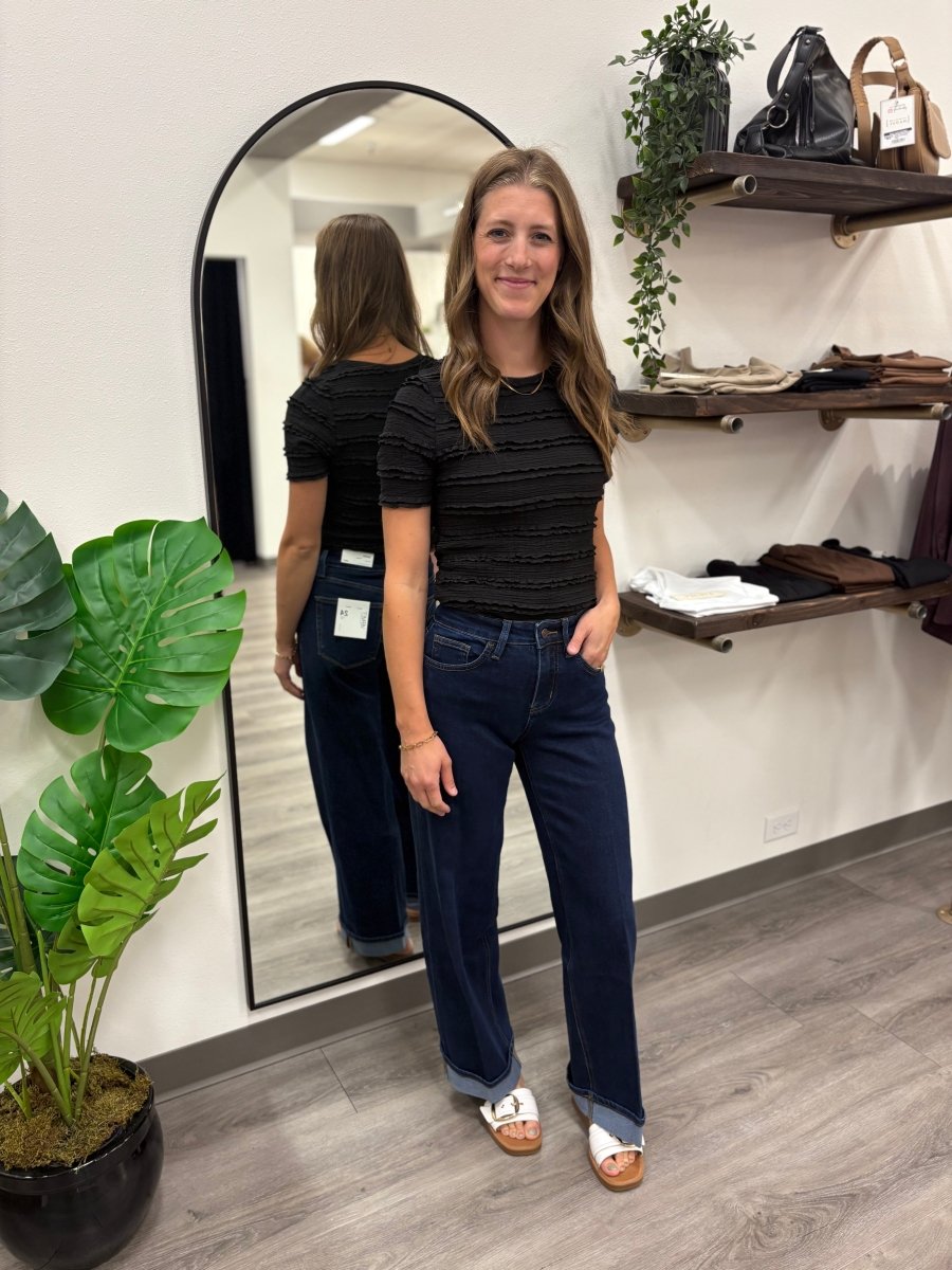 Lifestyle shot of model wearing wide leg jeans styled with casual top — Three:Twelve Boutique