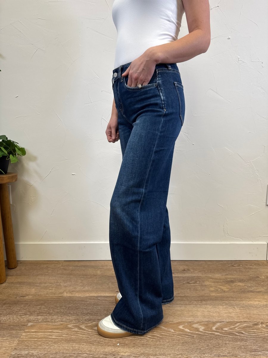 Side view of high rise dark wash wide leg jeans on model showing full length fit — Three:Twelve Boutique