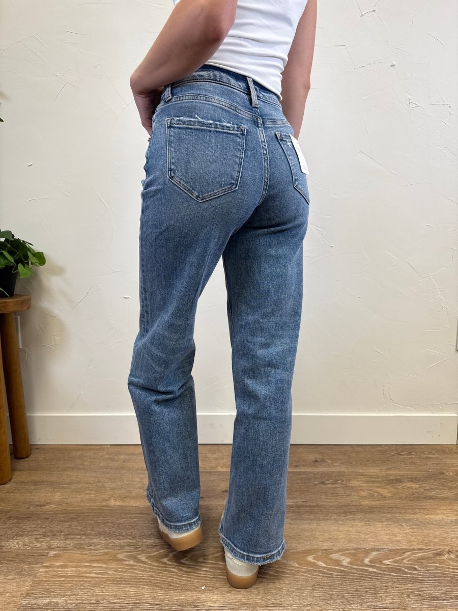 Back view of model wearing wide leg jeans highlighting high rise waist and back pockets — Three:Twelve Boutique