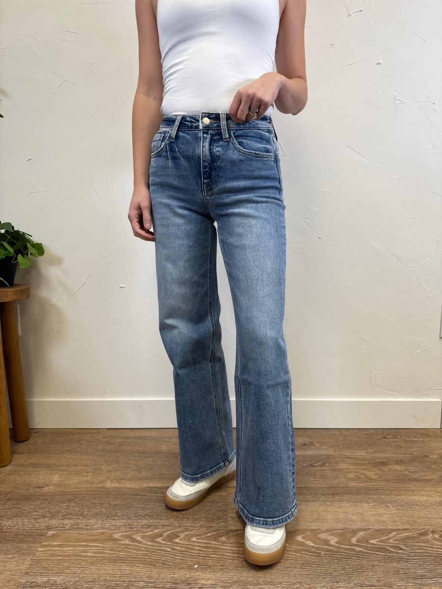 Lifestyle shot of model wearing wide leg jeans styled with casual top — Three:Twelve Boutique