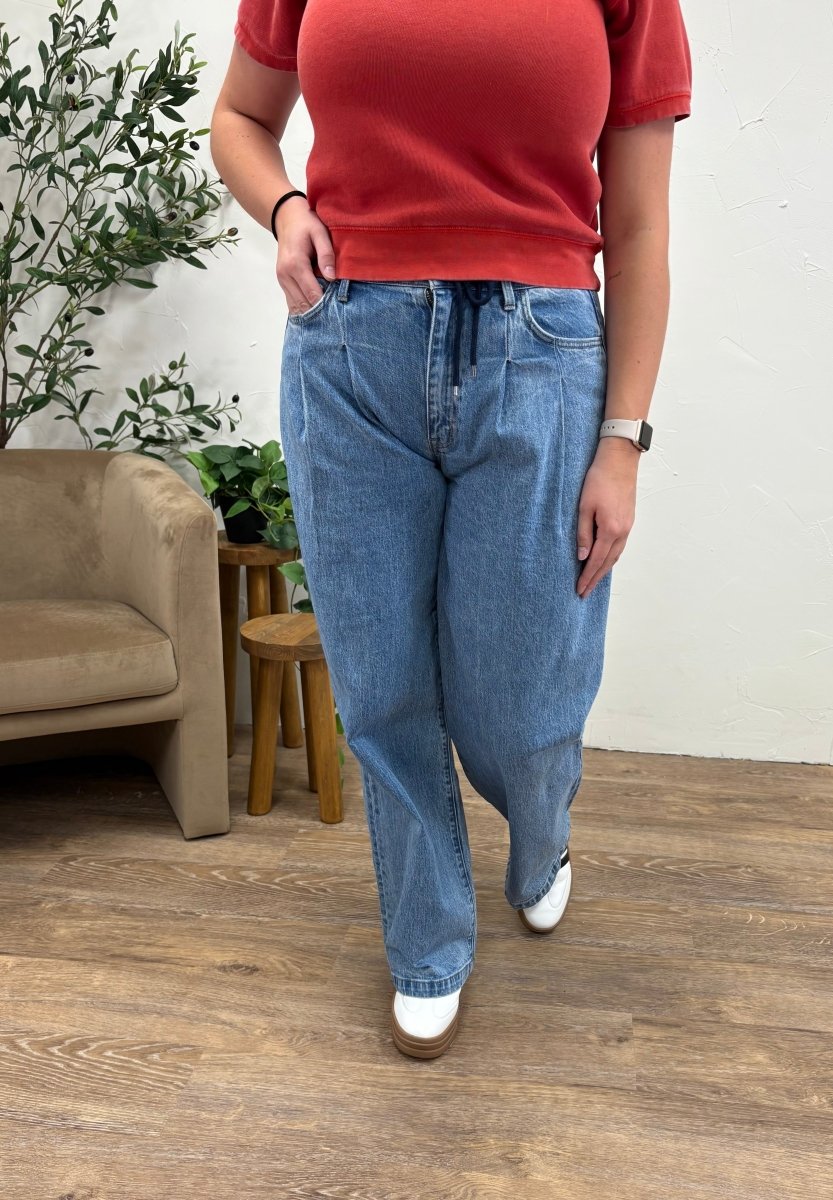 Front view of high rise pleated drawstring wide leg jeans on model — Three:Twelve Boutique