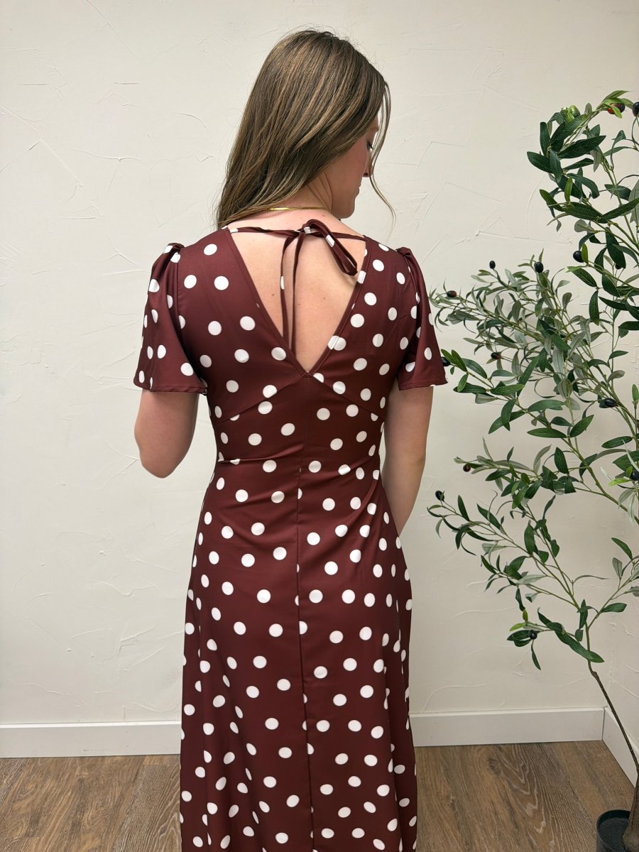 Back view of blue polka dot maxi dress on model showing full length silhouette — Three Boutique