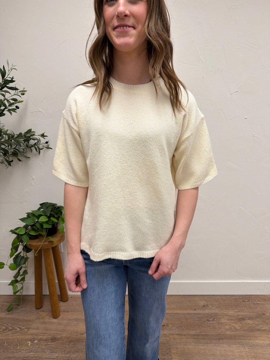 Lifestyle shot of model wearing short sleeve knit sweater styled with casual outfit — Three:Twelve Boutique