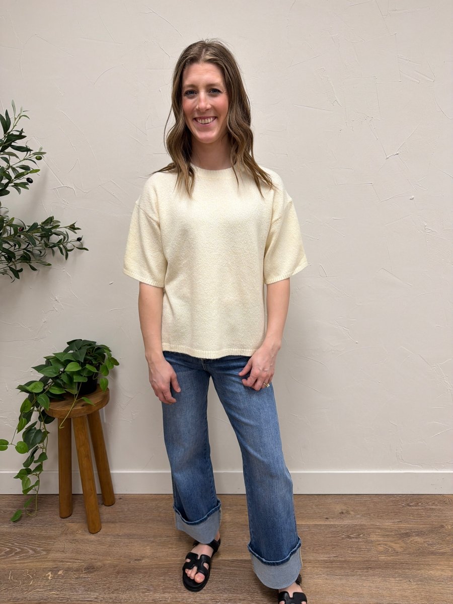 Lifestyle shot of model wearing short sleeve knit sweater styled with casual outfit — Three:Twelve Boutique