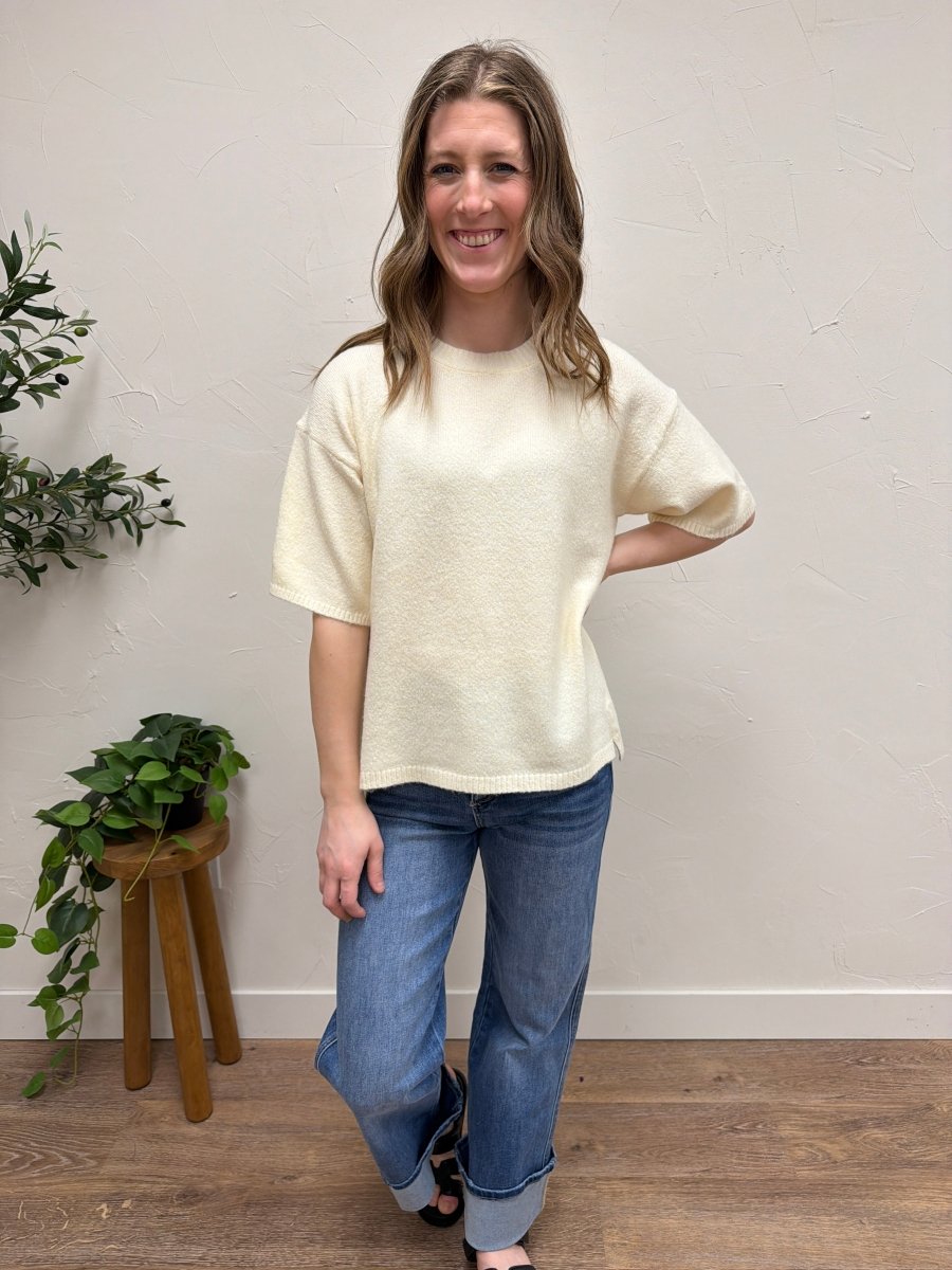 Lifestyle shot of model wearing short sleeve knit sweater styled with casual outfit — Three:Twelve Boutique