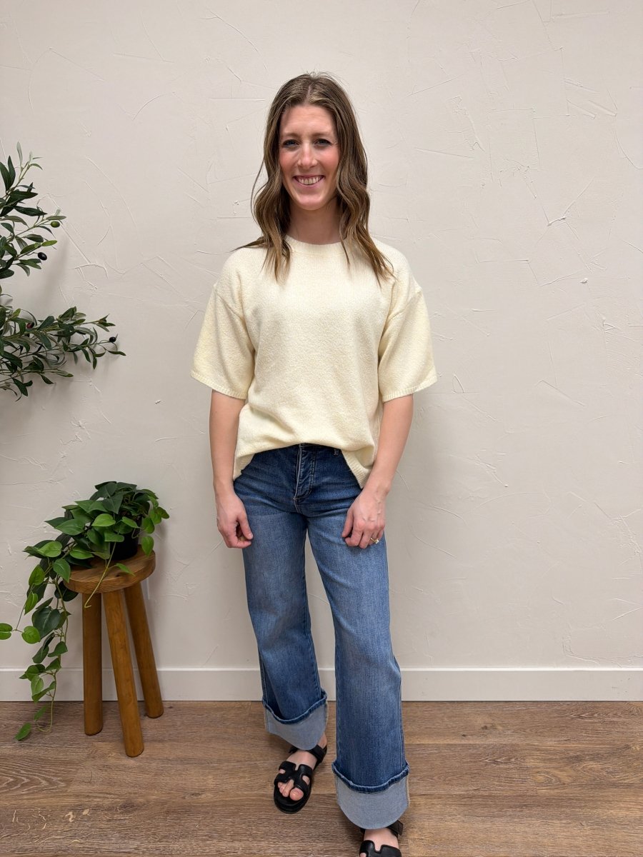 Lifestyle shot of model wearing short sleeve knit sweater styled with casual outfit — Three:Twelve Boutique