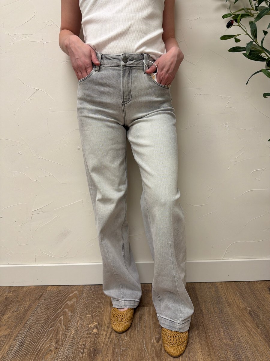 Lifestyle shot of model styled with casual top and sneakers wearing baggy jeans — Three:Twelve Boutique