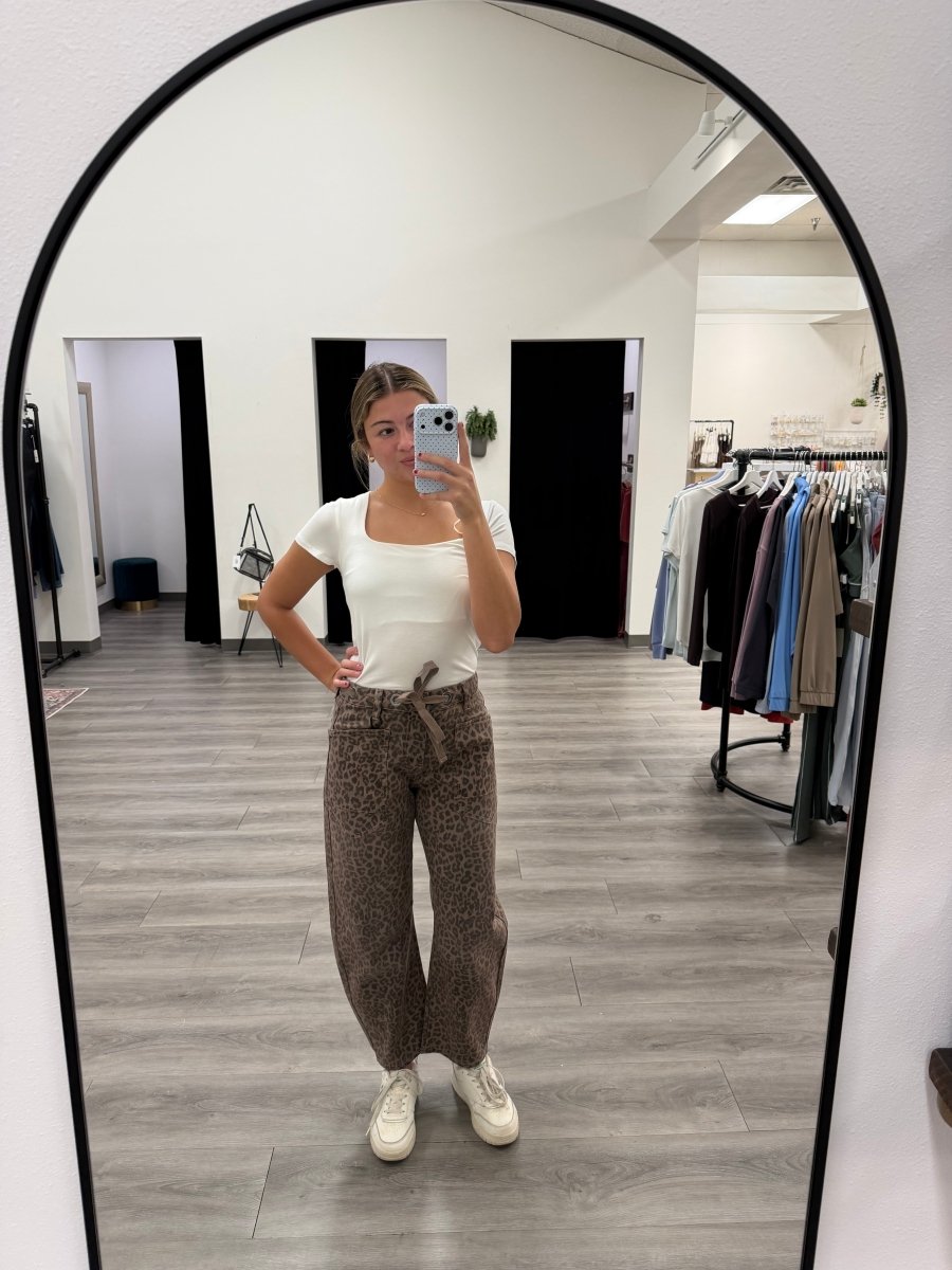 Lifestyle shot of model wearing slouchy crop barrel jeans with casual top and sneakers — Three:Twelve Boutique