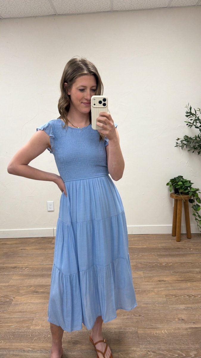 Lifestyle shot of model wearing tiered smocked midi dress in casual setting — Three:Twelve Boutique