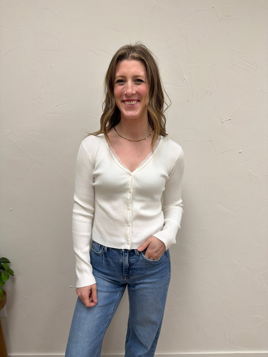 Lifestyle shot of model wearing V-Neck ribbed cardigan paired with denim and boots — Three:Twelve Boutique