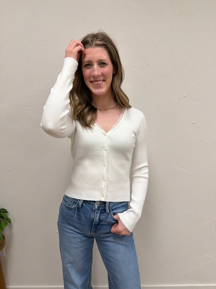Lifestyle shot of model wearing V-Neck ribbed cardigan paired with denim and boots — Three:Twelve Boutique
